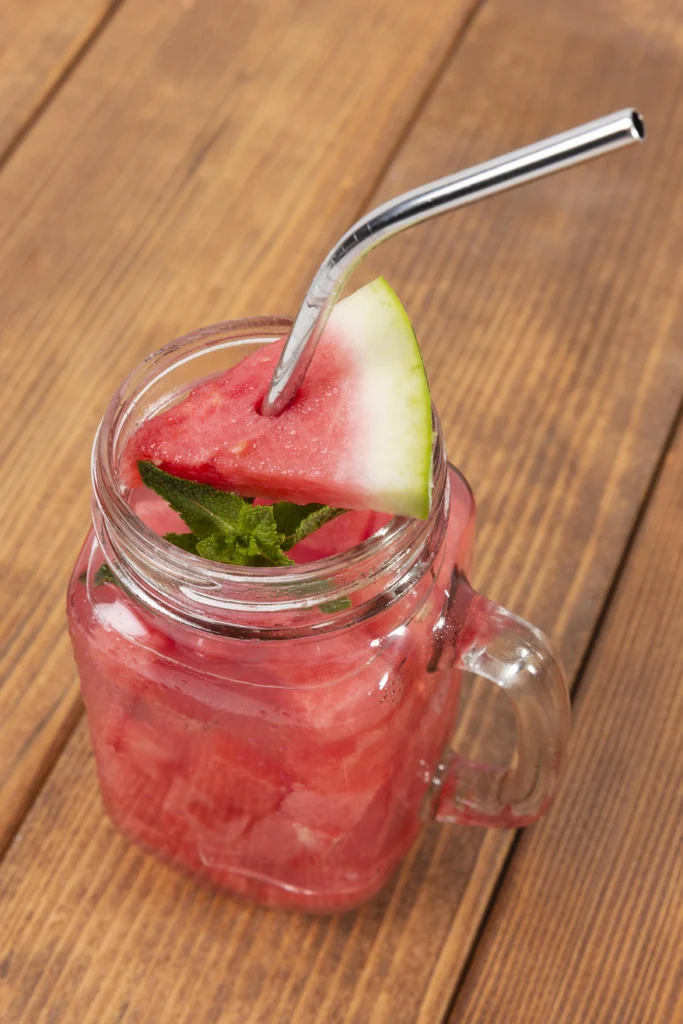 Iced Watermelon Mint Mojito with basil garnish and amber straw.