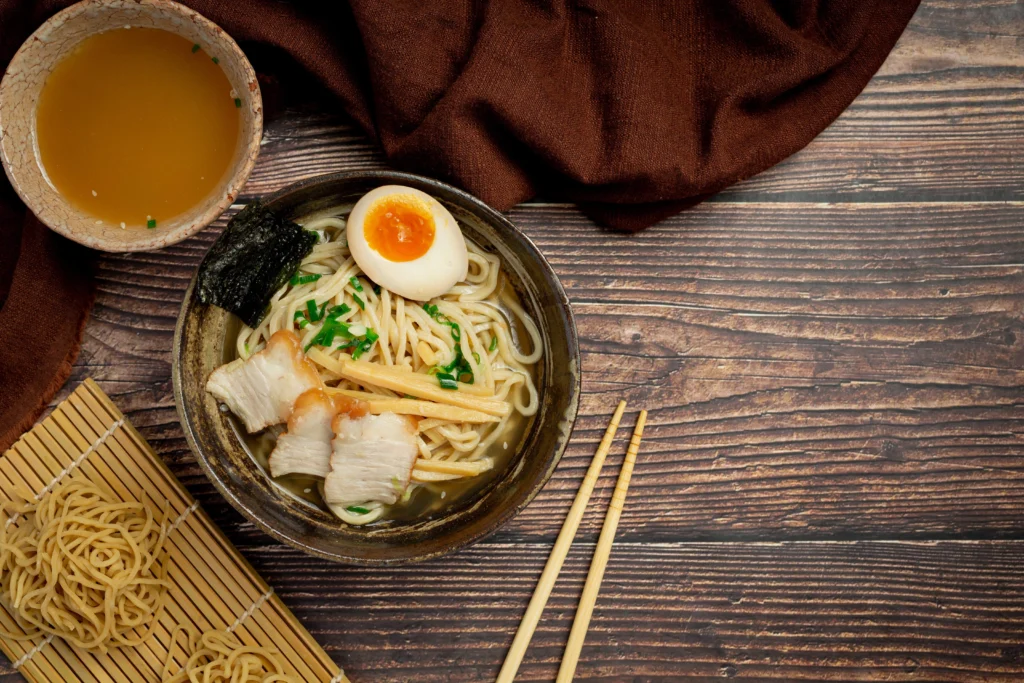 Asian miso ramen served with chopsticks, featuring spicy kimchi, soft egg, and fresh sprouts.