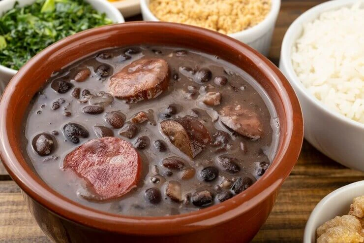 Traditional Brazilian Feijoada stew with black beans, pork, and rice on a plate.