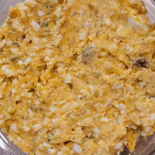 Homemade devilled egg potato salad with chopped eggs, chives, and seasoning.