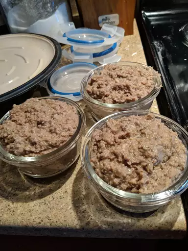 Authentic homemade pork creton with parsley garnish and bread slice on a rustic plate.