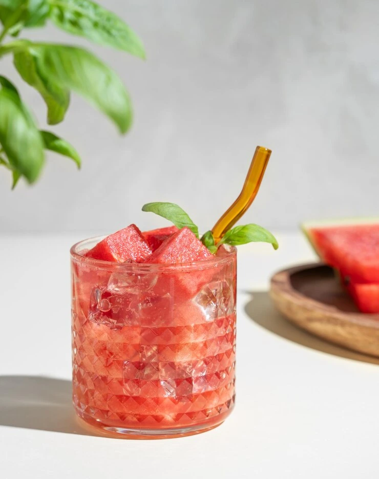 Watermelon Mint Mojito with ice and basil in a crystal glass on a summer day.