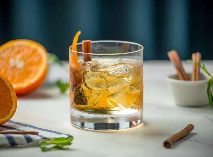 A chilled Scotch Honey Highball cocktail in a tall glass with ice, garnished with a lemon twist.