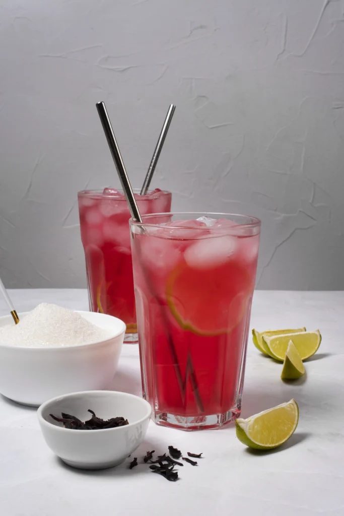 Close-up of a chilled Strawberry Lime Vodka Smash cocktail garnished with mint and lime.