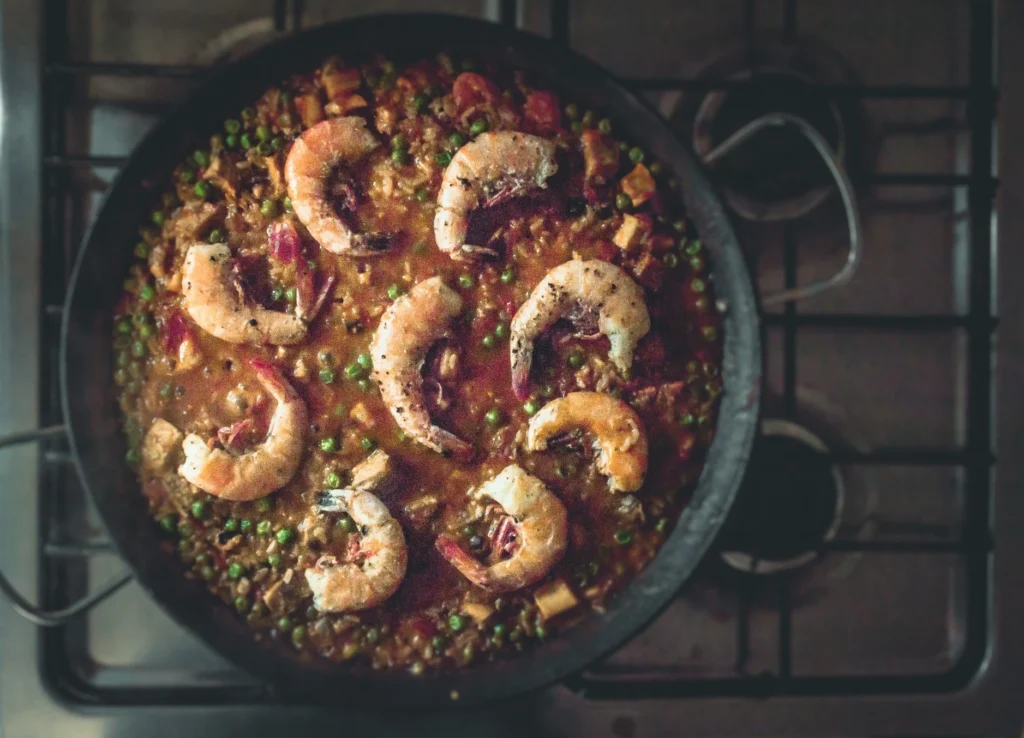 Gambas al Ajillo on a white plate with crusty bread.