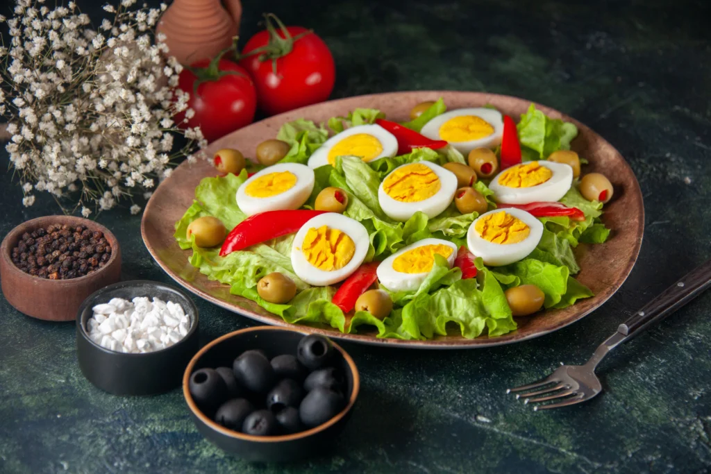 Fresh Classic Cobb Salad featuring diced avocado, hard-boiled eggs, cherry tomatoes, bacon, and grilled chicken on a bed of romaine lettuce.