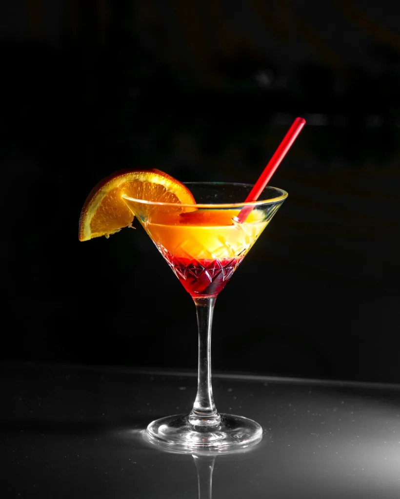 Clean image of a Manhattan cocktail with lemon garnish in a martini glass against a white background.
