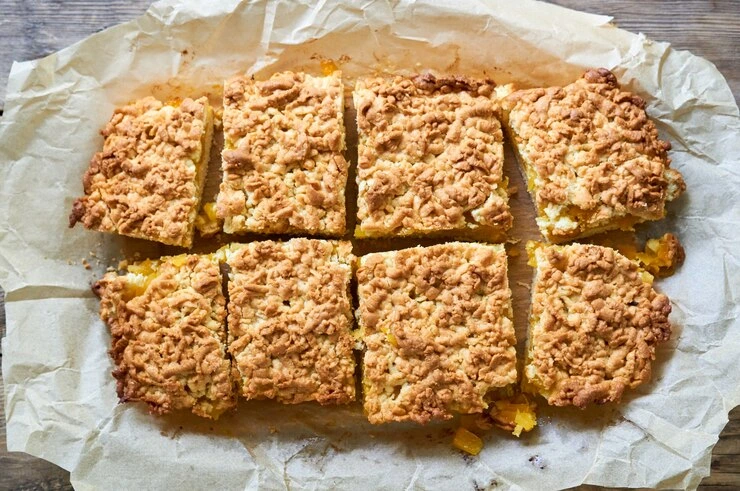 Three lemon crumb bars stacked, showing the creamy filling and crumbly topping.