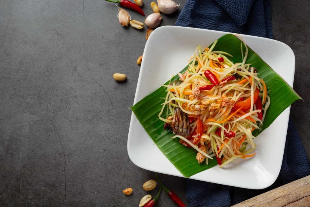 salade-de-papaye-servie-avec-nouilles-de-riz-et-salade-de-legumes-decore-avec-des-ingredients-thailandais