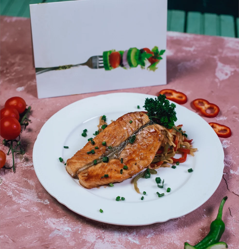 Grilled Wild Alaskan Salmon with creamy sauce and herb mash on a white plate.